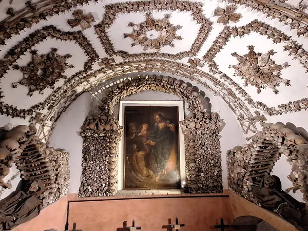 A painting of the raising of Lazarus framed by bone ornaments in the Crypt of the Resurrection, Capuchin Crypt, Rome.