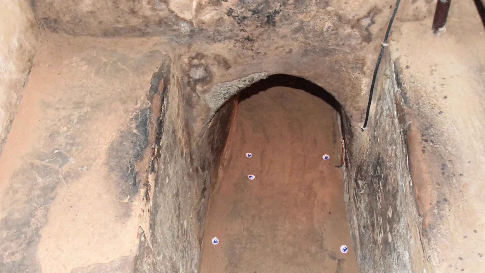 A tunnel entrance at Củ Chi, widened for visitors, cut into the forest floor