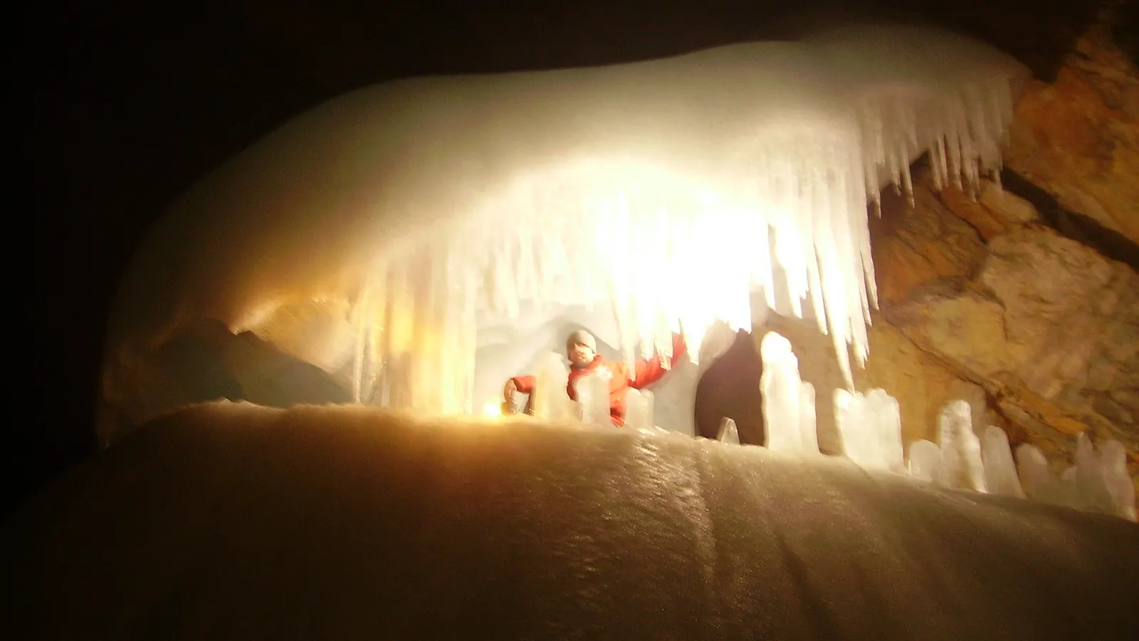 Carbide lamps lighting an ice formation with icicles inside the Eisriesenwelt at Werfen