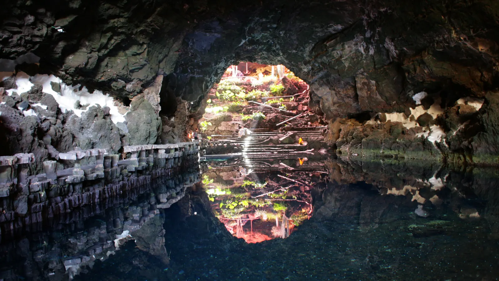 The lit turquoise pool at Jameos del Agua on Lanzarote, white walls against black lava rock