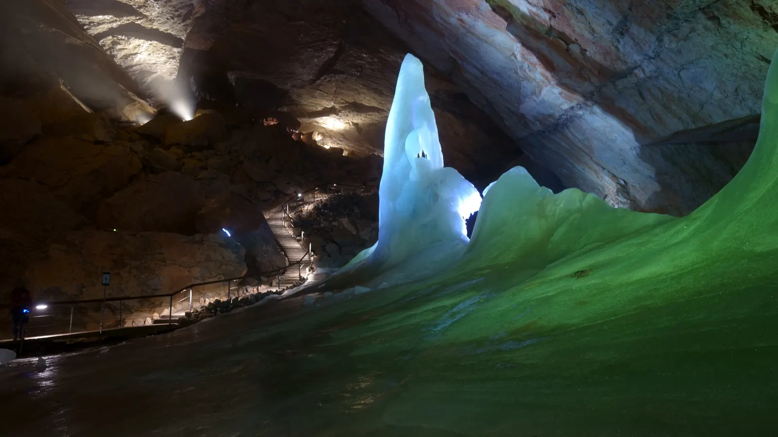 An ice figure in the Parzival Hall of the Dachstein Giant Ice Cave, with the lit visitor path behind it