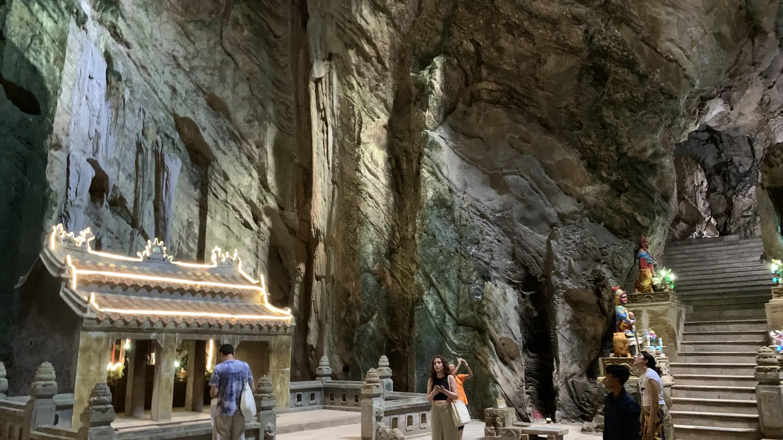 The main chamber of the Huyền Không cave in the Marble Mountains, with its shrine, stairway and shaft of daylight