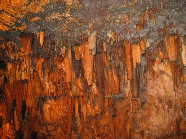 Orange-lit curtains of stalactites cover the ceiling of Drogarati Cave on Kefalonia.